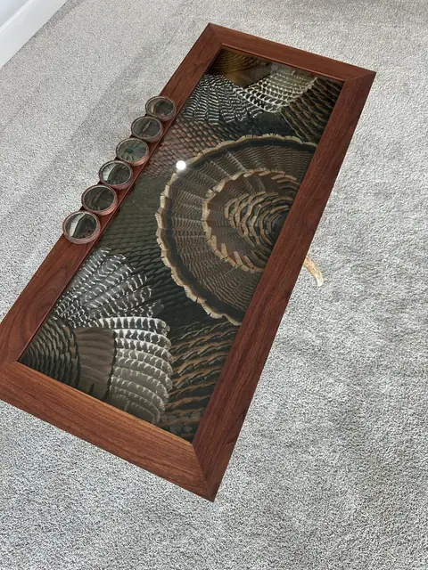 Custom turkey feather art table with feathers displayed under glass, built by All Feathers Taxidermy