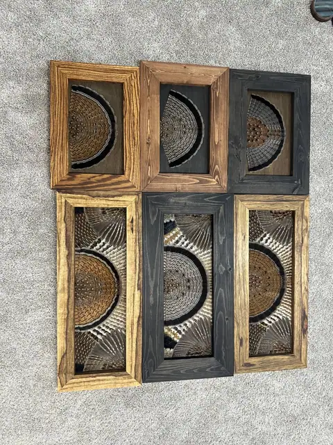 Six ruffed grouse feather art pieces in natural, brown and black wood frames, including fans on stained wood backgrounds, by All Feathers Taxidermy
